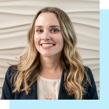 Smiling person with long blonde hair wearing a blazer