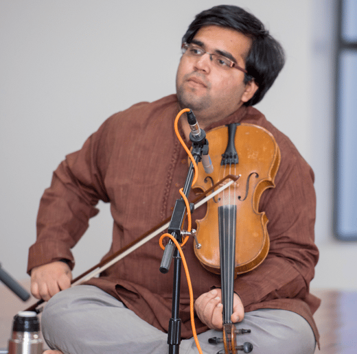A photograph of Ashwin Kalyan playing the violin.